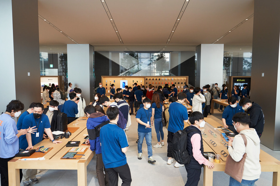 Customers and team members are shown at the grand opening of Apple Myeongdong.