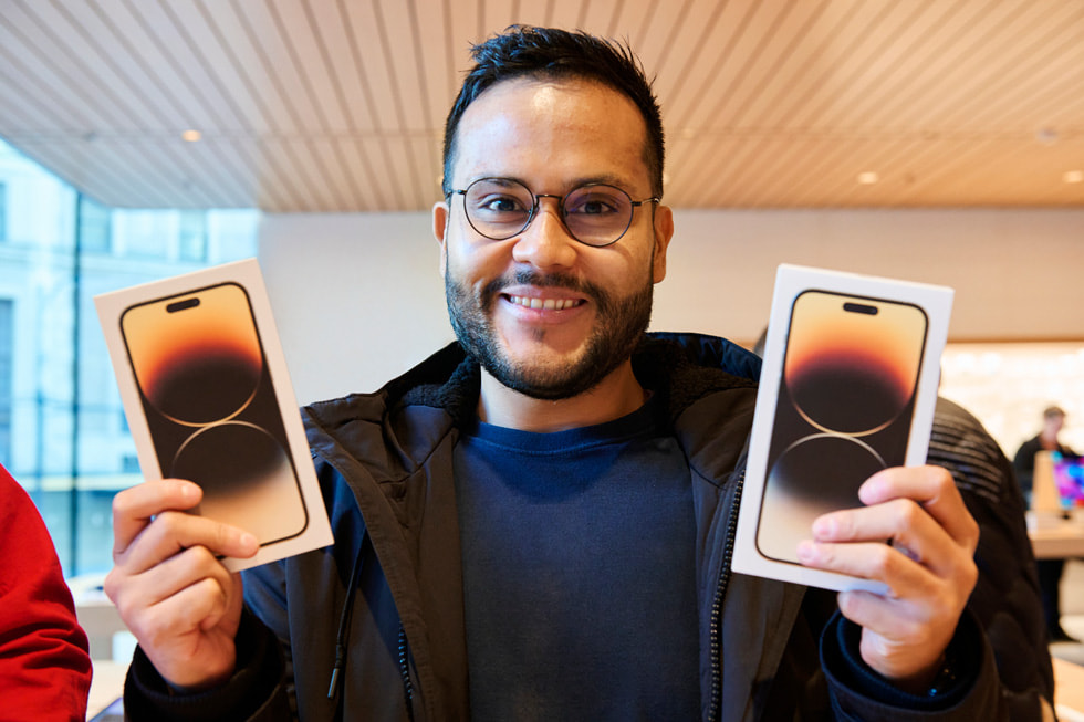 A customer shows off their new iPhone 14 Pro Max purchases at the new Apple Pacific Centre in Vancouver, Canada.