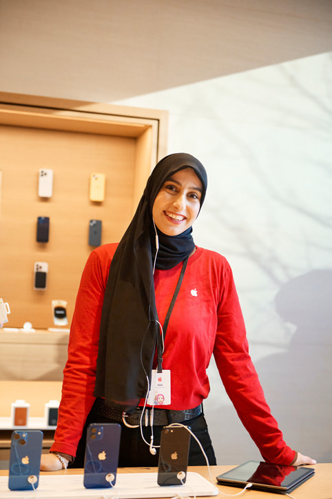 An Apple Specialist standing on an iPhone display table inside the new Apple Pacific Centre in Vancouver, Canada.