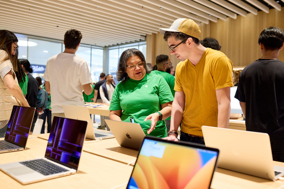 A team member shows a customer the latest Mac lineup.