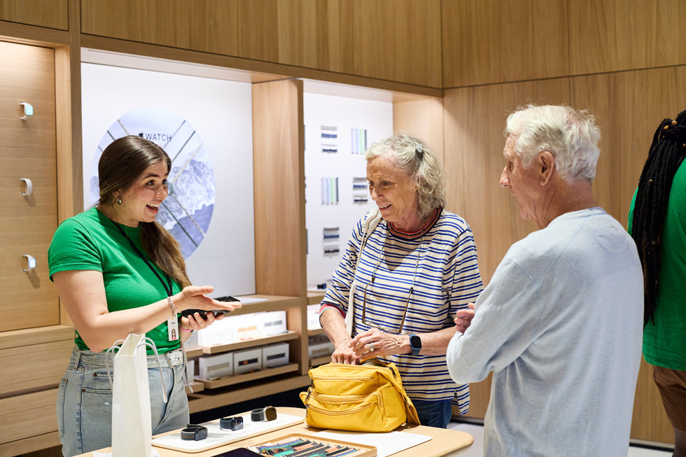 A team member assists a customer at the Apple Watch display.