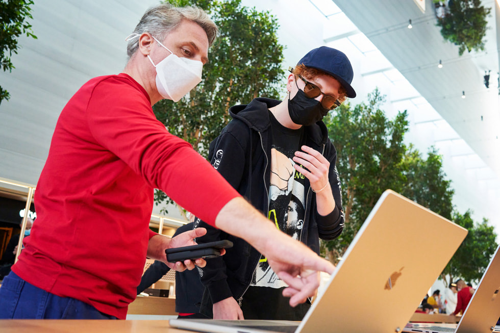 Un miembro del equipo del Apple The Grove enseña la nueva MacBook Pro a un cliente.