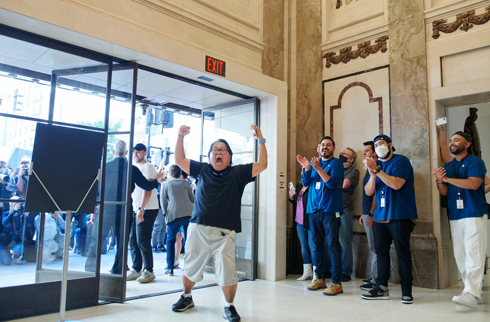 Un client lève les bras en signe de victoire en entrant dans Apple Tower Theatre.