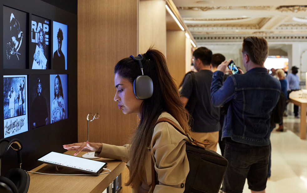 Une cliente utilise un iPad Pro avec des AirPods Max.