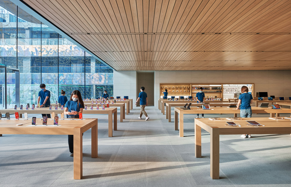 Apple employees at product display stations.