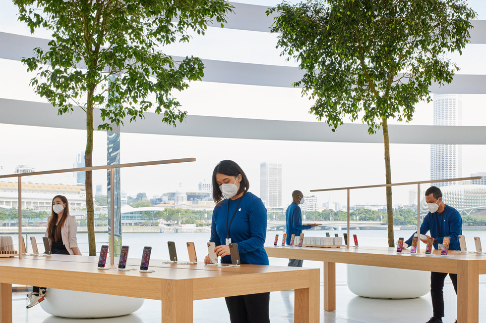 An Apple team member sets up an iPhone on display stands.