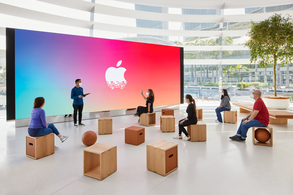 Clientes sentados y escuchando a un integrante del equipo de Apple.