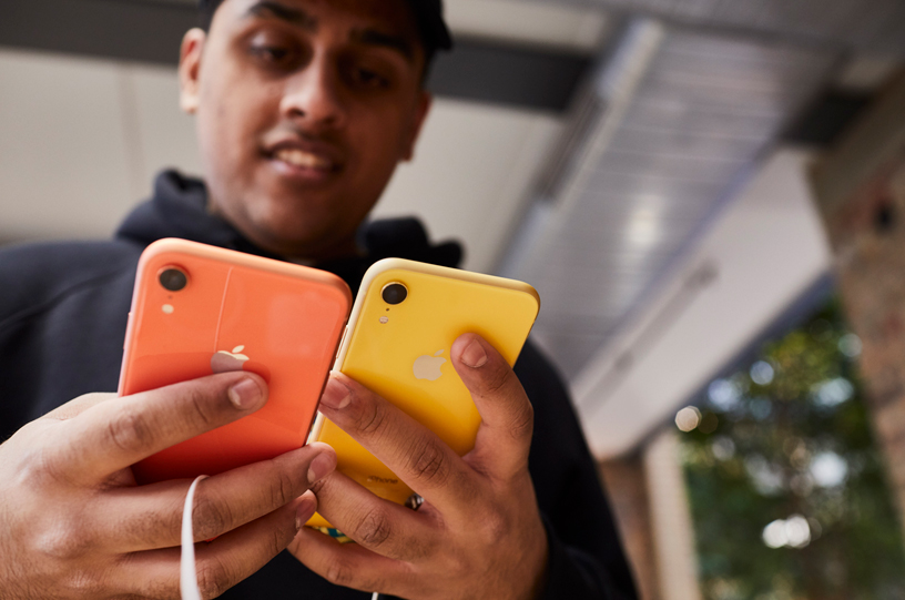 顧客正在比較珊瑚色款和黃色款 iPhone XR。