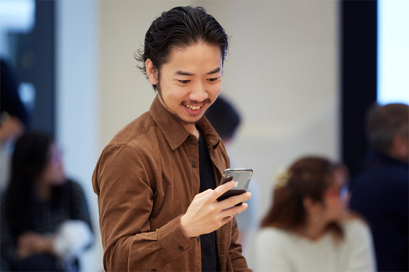 A young man interacting with the new iPhone Xs.