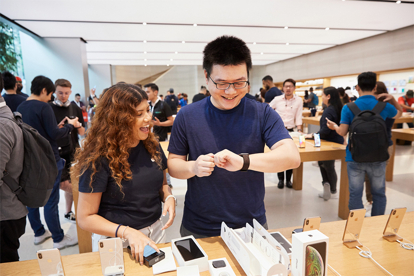 Une membre de l’équipe Apple aide un client qui porte une Apple Watch Series 4.