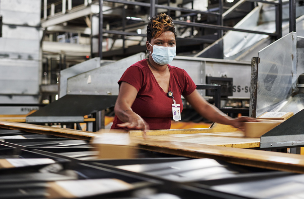 En medarbetare på UPS Worldport sorterar Apple-förpackningar för leverans.