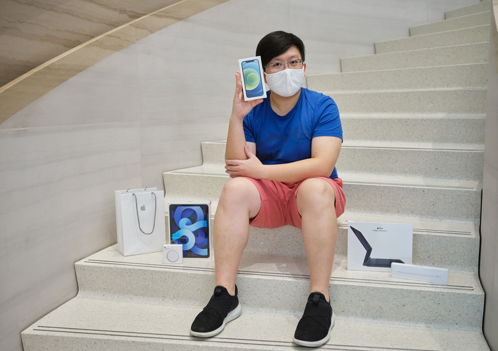 Ein Kunde in Apple Orchard Road zeigt sein neues iPhone 12, iPad Air und MagSafe Ladegerät.
