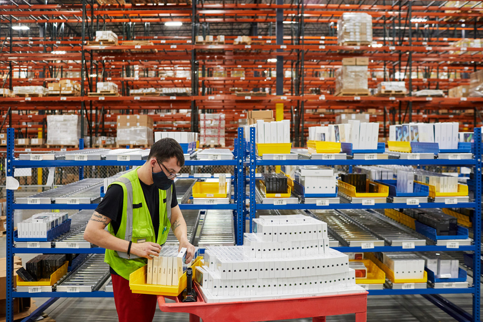 A distribution center employee preparing Apple product for shipment. 