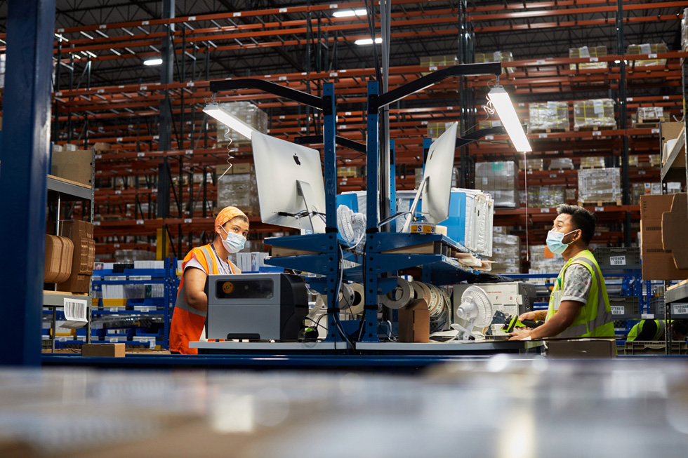 Distribution center employees review orders for Apple product shipment. 