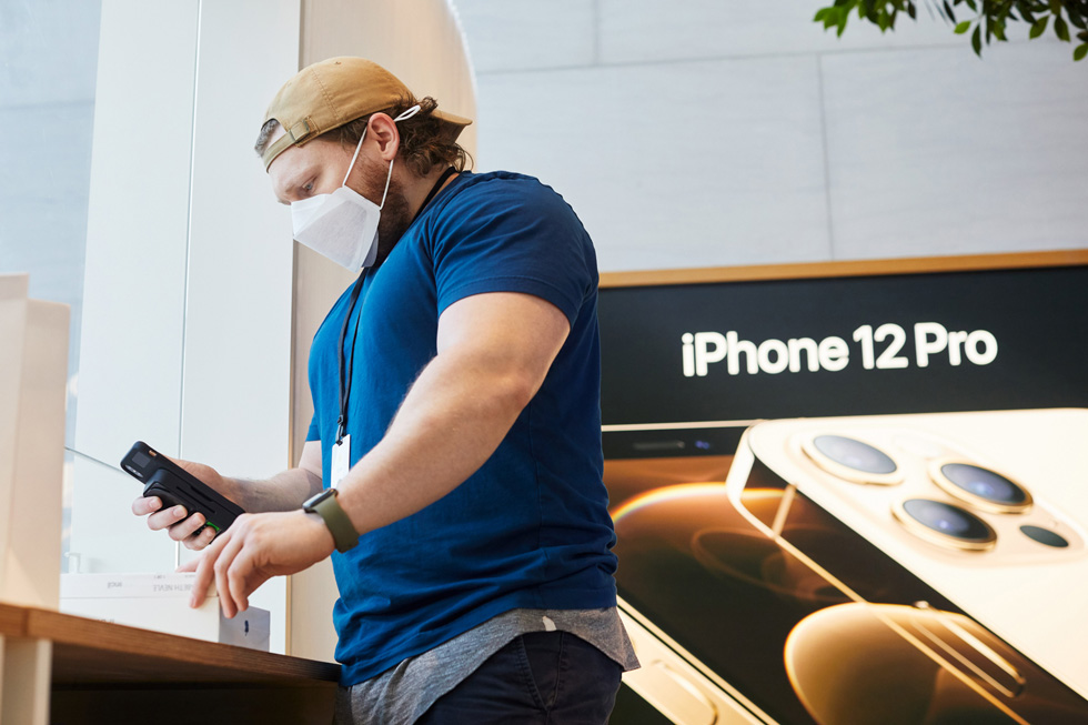 An Apple employee scans Apple products at Apple Highland Village.