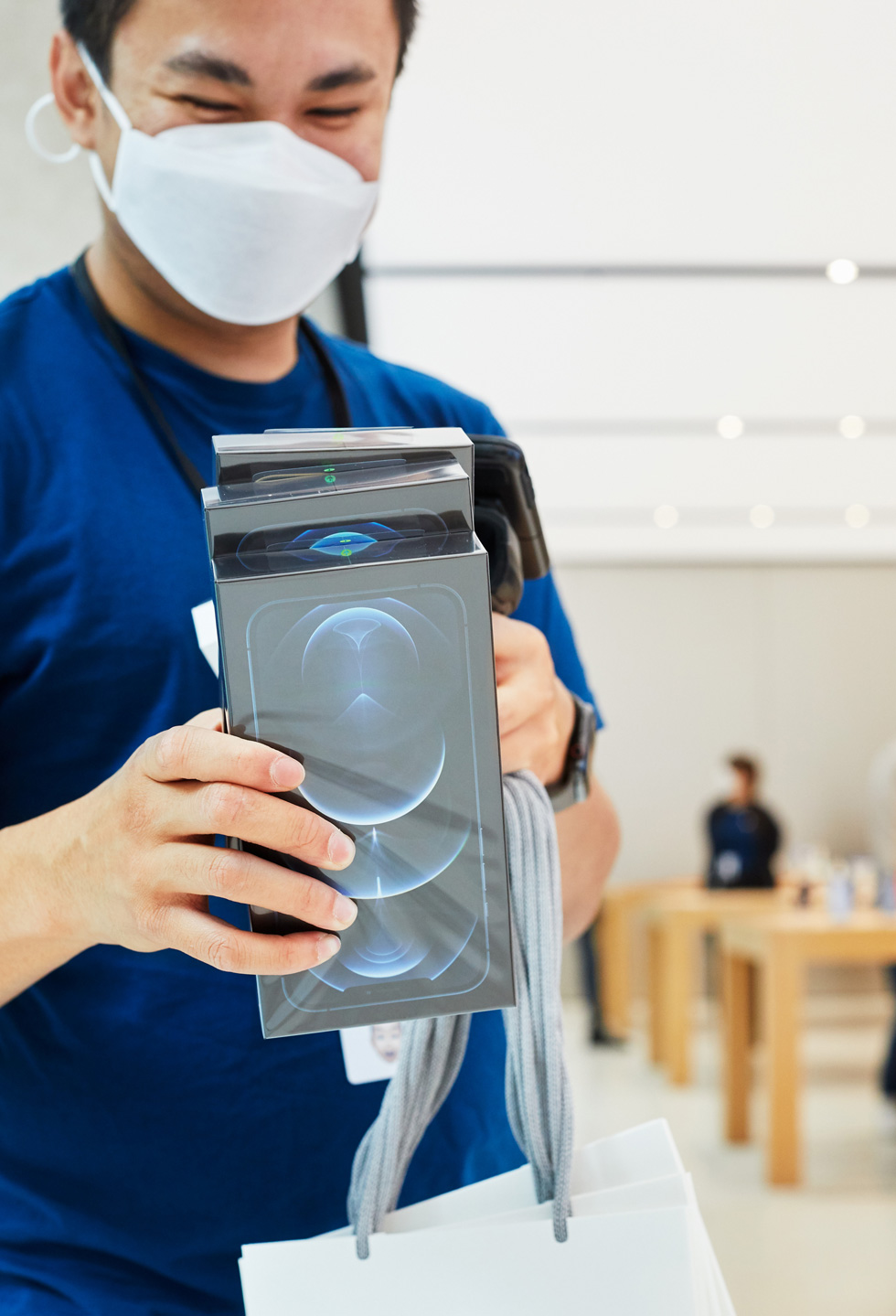 An Apple Sydney team member scans boxes of iPhone 12 Pro Max.