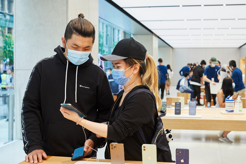 Customers at Apple Sydney test out the new iPhone 12 Pro Max at one of the display tables.