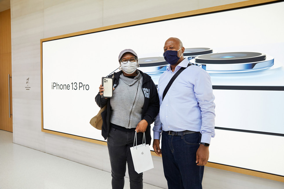 Une cliente d’Apple Fifth Avenue accompagnée d’un ami pose avec l’iPhone 13 Pro qu’elle vient d’acheter.