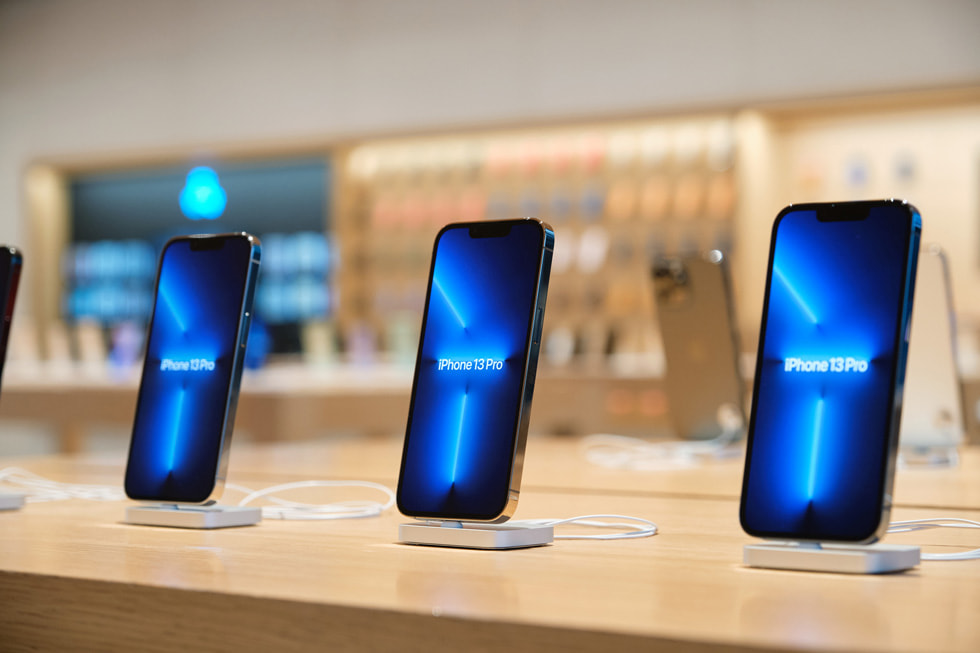 Gros plan sur des iPhone 13 Pro en démonstration sur une table d’Apple Sanlitun.