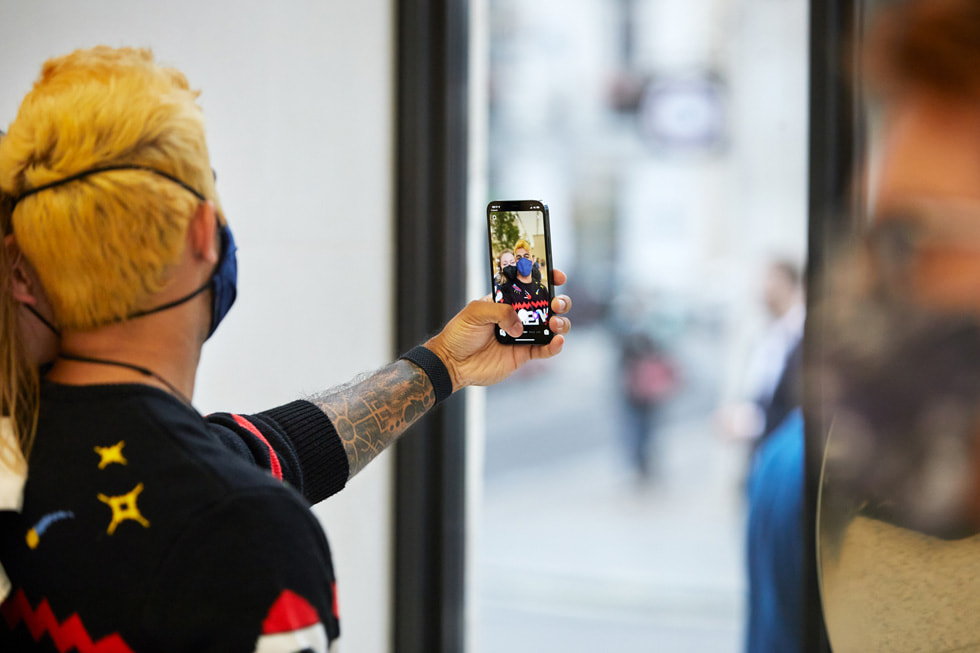 عملاء يلتقطون صورة سيلفي في متجر Apple Regent Street باستخدام iPhone 13 Pro الجديد.