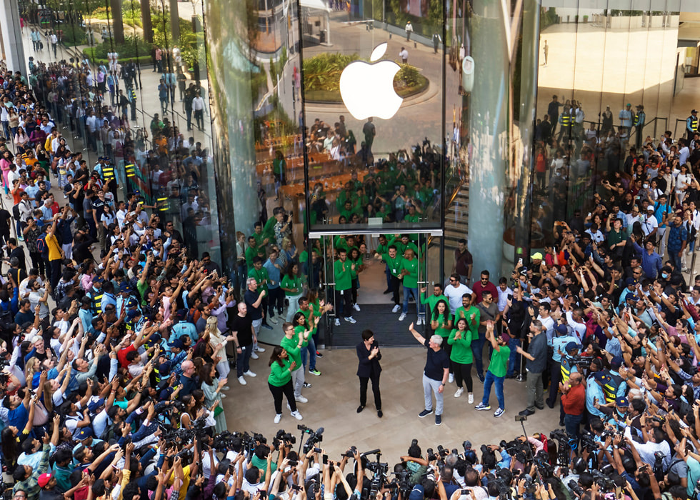 Tim Cook, Deirdre O'Brien und Teammitglieder applaudieren den ersten Kund:innen bei Apple BKC.
