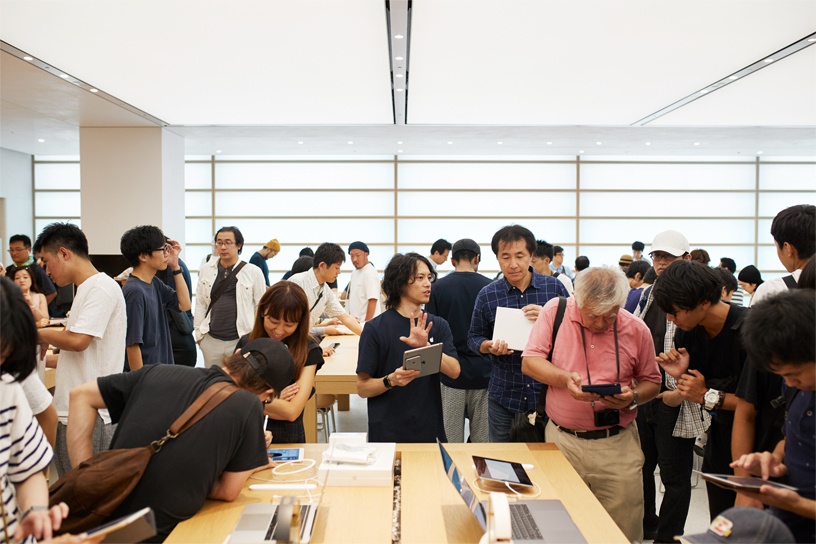 Crowd of customers mingling with employees at Apple Kyoto.