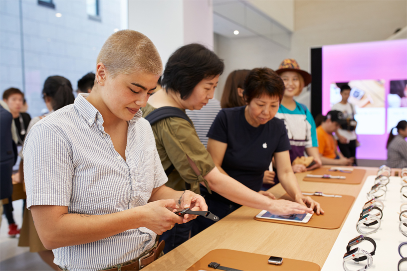 People looking at Apple Watches at a table at Apple Kyoto.