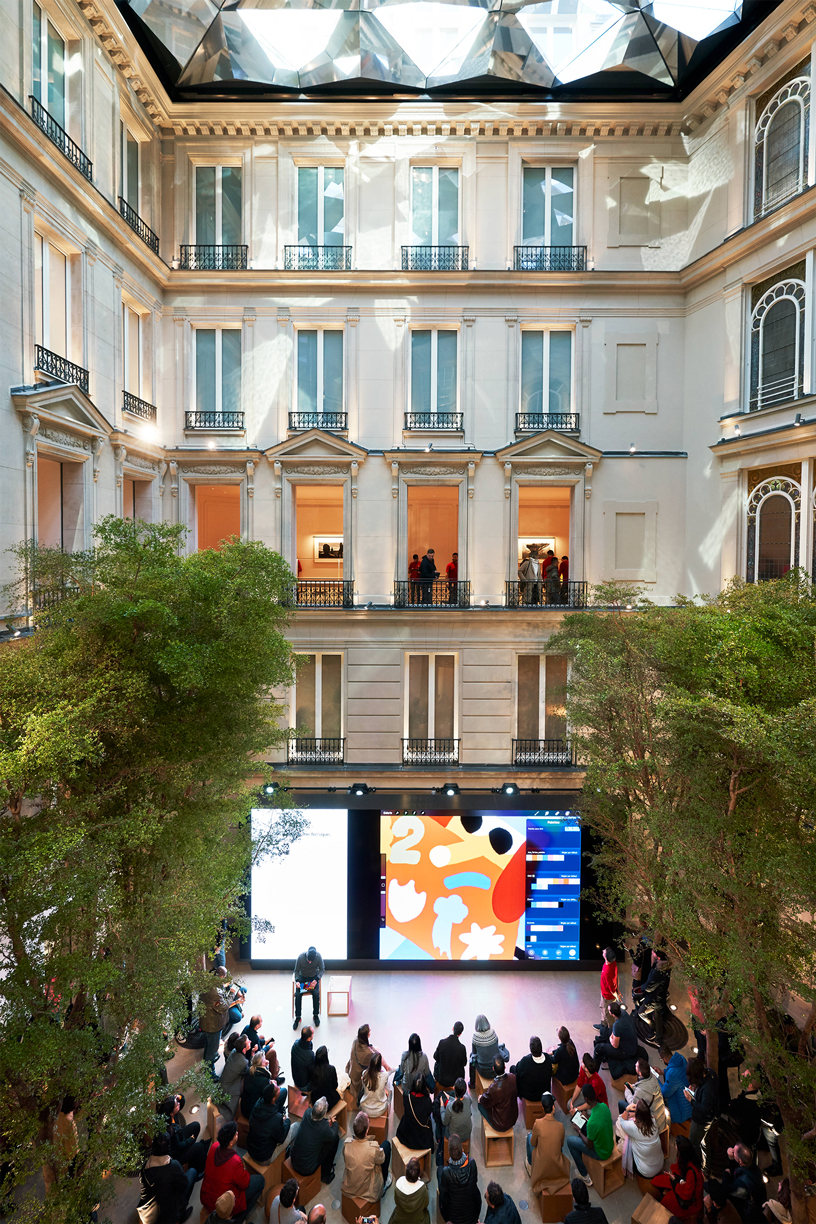 Un grupo de clientes sentados en el Forum de Apple Champs-Élysées.