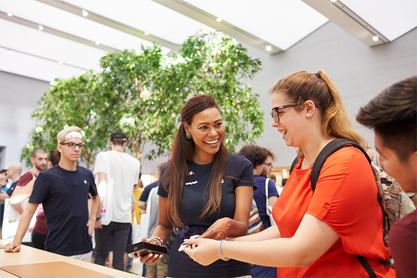 An Apple Piazza Liberty team member laughs with a visitor.