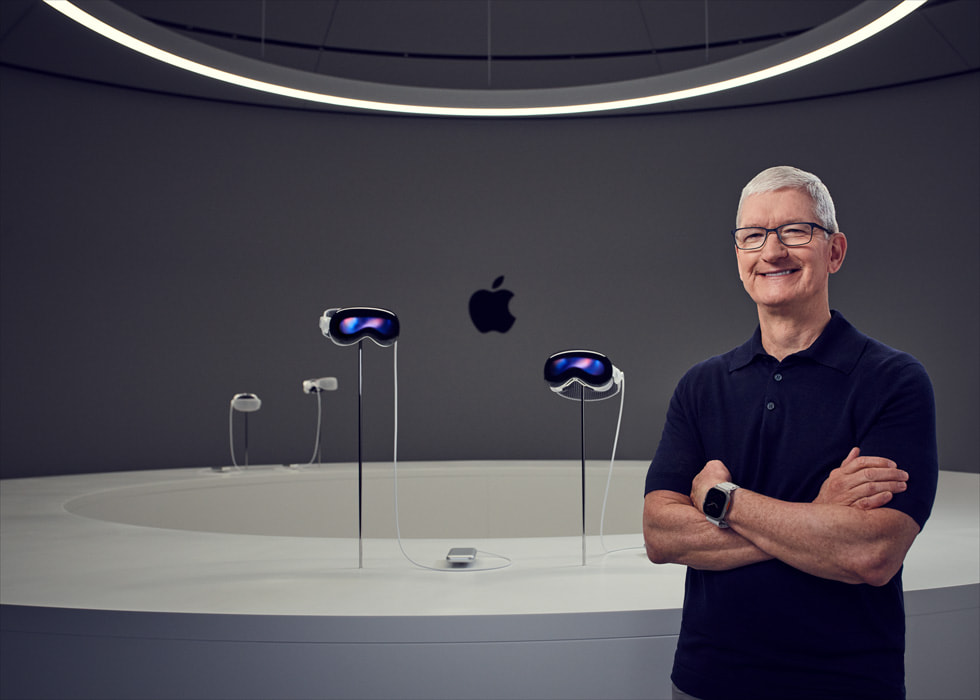 Tim Cook, CEO di Apple, accanto ad alcuni dispositivi Apple Vision Pro in esposizione.