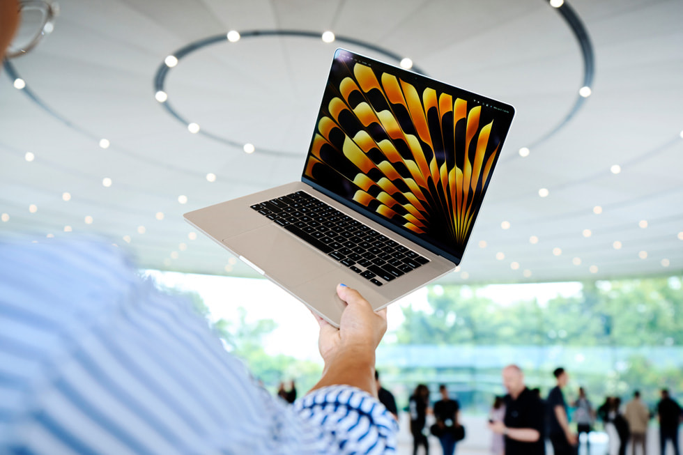 Eine Person hält während der WWDC das neue 15" MacBook Air im Apple Park hoch.