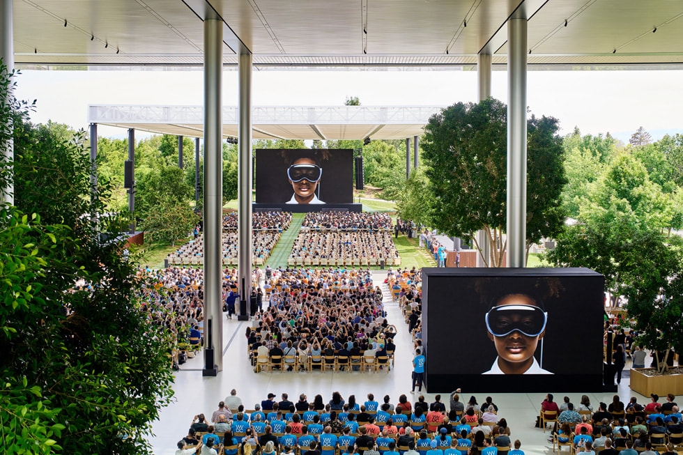 Hunderte von Entwickler:innen sitzen auf Stühlen im Apple Park und verfolgen die WWDC23 Keynote.