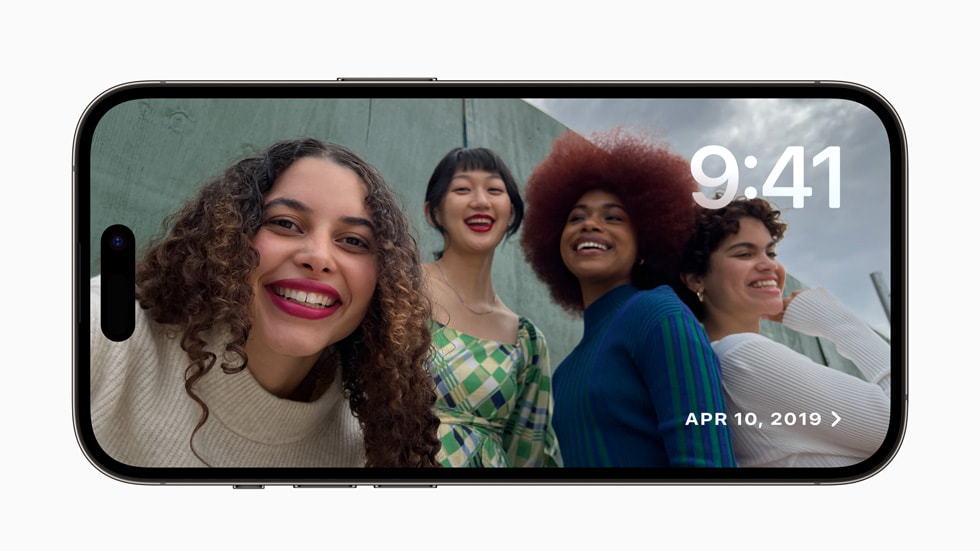 In iOS 17 on iPhone 14 Pro, the StandBy experience shows a group of friends posing together.