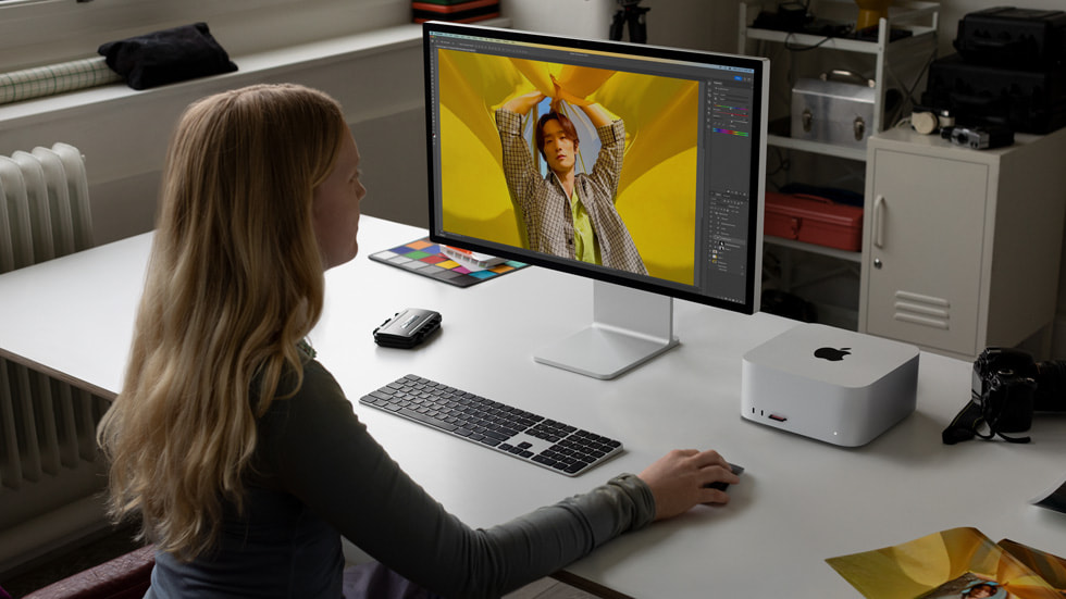 En person sidder ved en arbejdsstation og bruger Mac Studio og Mac Pro.