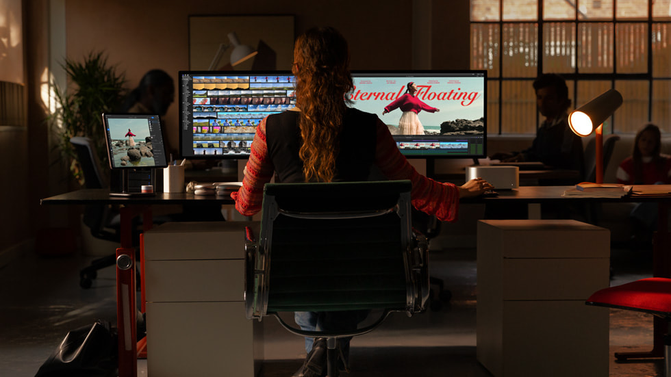 Una persona en su espacio de trabajo tipo loft usando la Mac Studio y la Mac Pro.