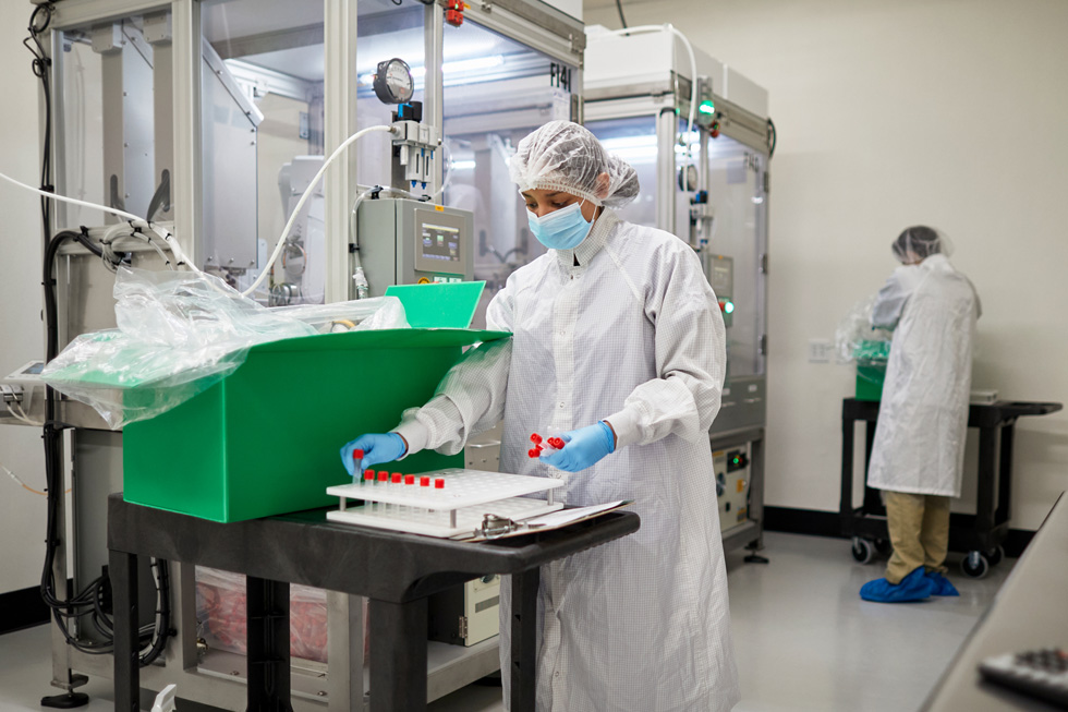 A COPAN Diagnostics worker stores vials on a rack tray. 