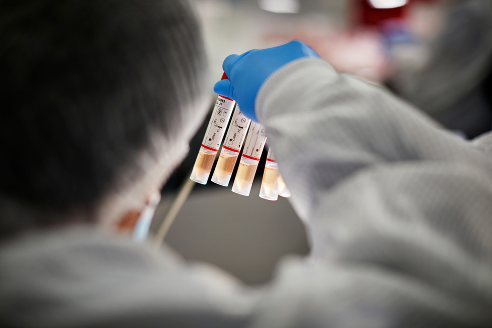 A lab worker at COPAN Diagnostics scrutinises vials.