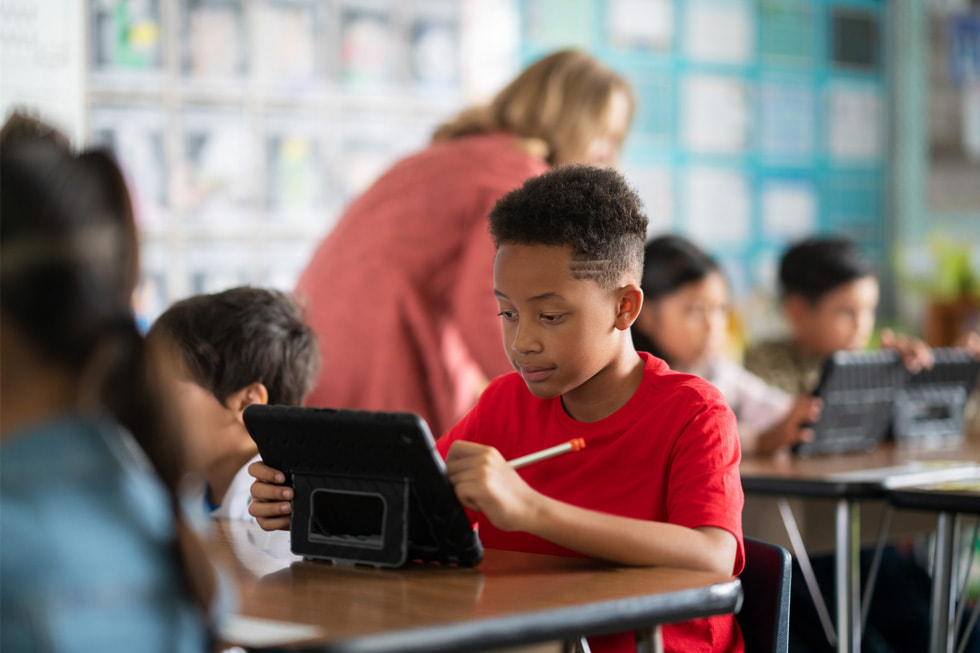 Un joven estudiante del distrito escolar unificado de Downey usa un iPad en un salón de clases.