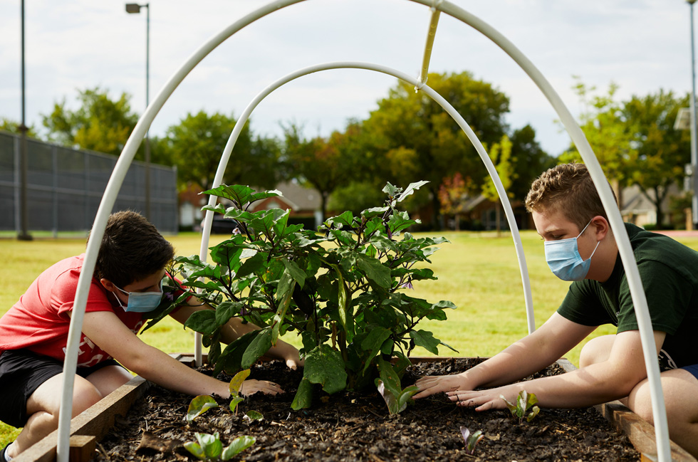 Annabeth Hook y Stayton Slaughter cuidan las plantas del jardín comunitario del centro Coppell Middle School East.