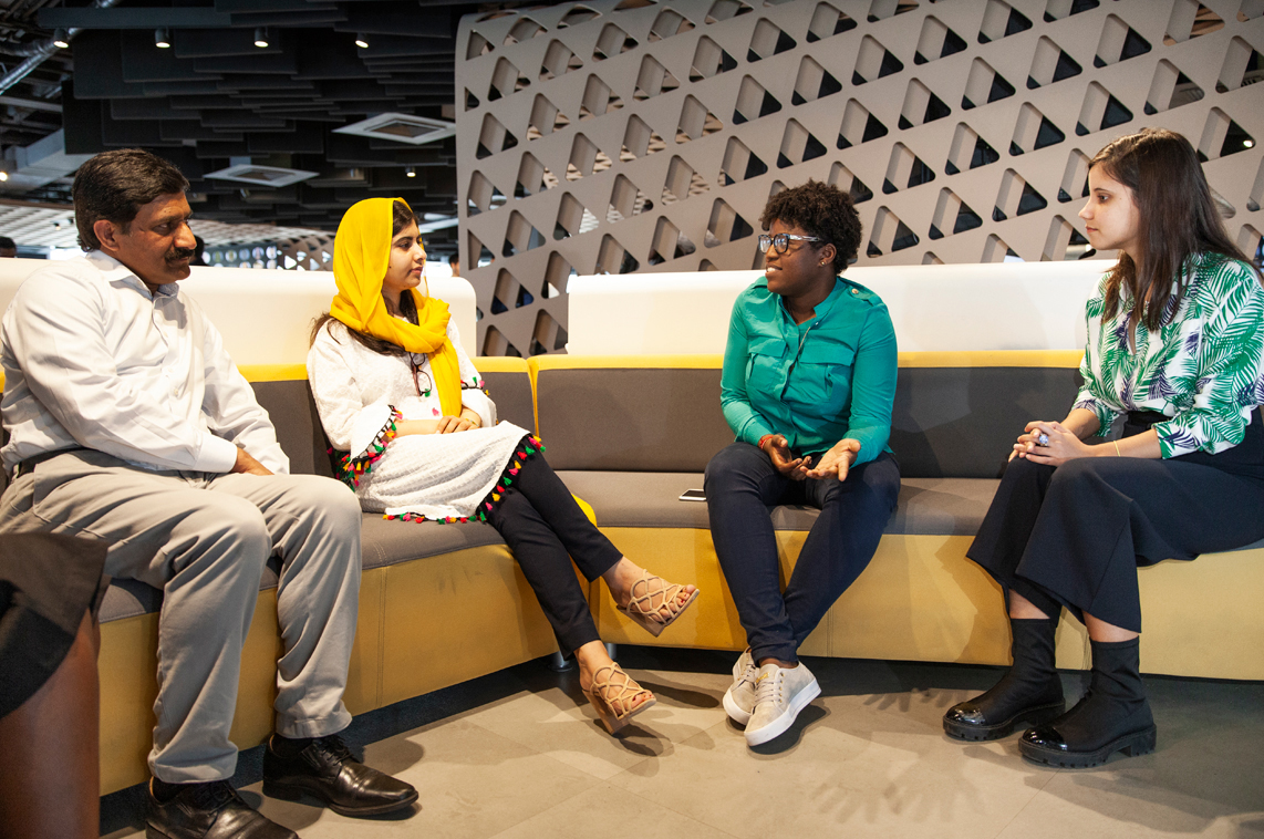 Malala Yousafzai seduta su un divano insieme a tre persone alla Apple Developer Academy di Rio.