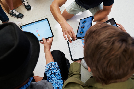 Estudiantes trabajan en un iPad.