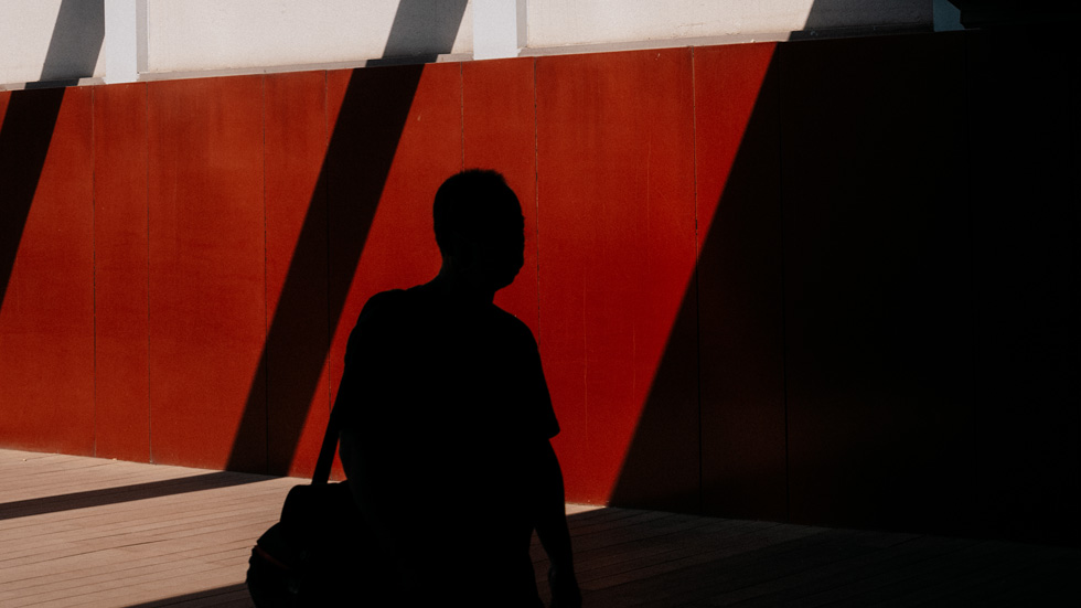 La silhouette d’Eric Zhang, se détachant sur un mur rouge.