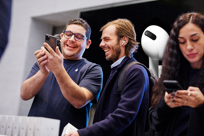 Un employé de la boutique Apple Piazza Liberty aide un client à configurer ses AirPods Pro.