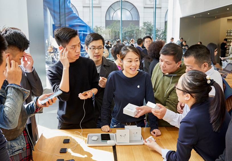 Clientes alrededor de una mesa en Apple Nanjing East en Shanghái.