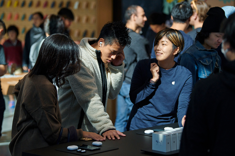 Des clients essaient des AirPods Pro avec des employés d’Apple Omotesando à Tokyo.