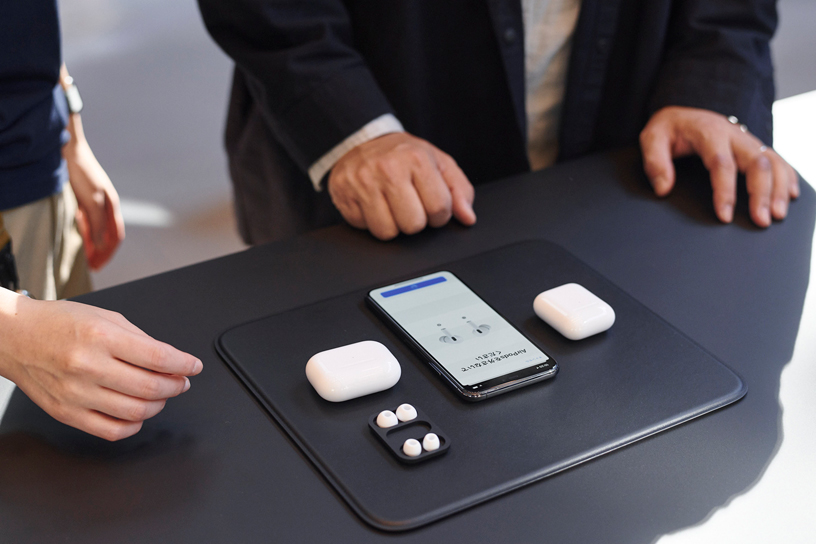 AirPods Pro cases and iPhone on a table at Apple Omotesando in Tokyo.