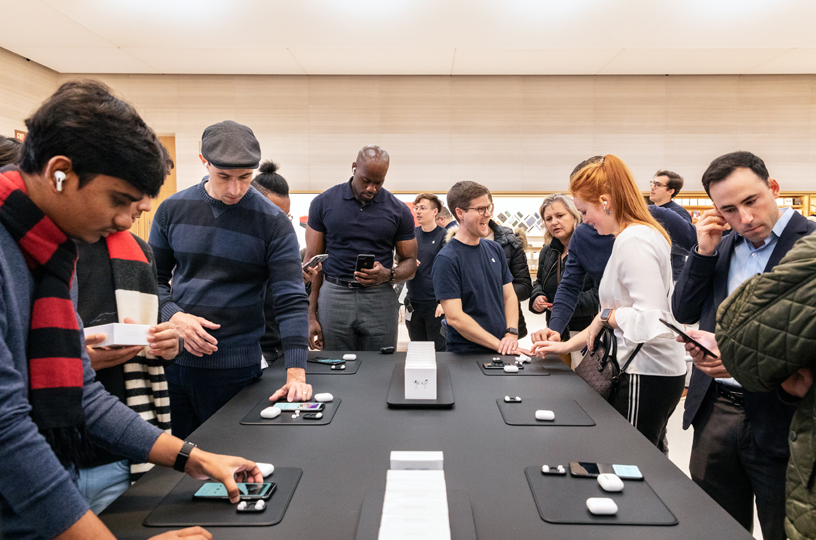 Des clients sont rassemblés autour des AirPods Pro à Apple Fifth Avenue à New York.