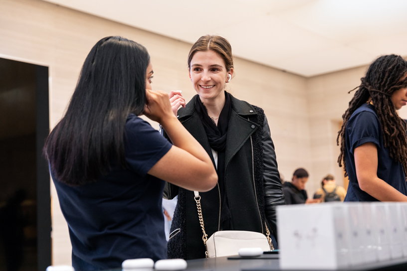 Une membre de l’équipe Apple fait la démonstration de l’ajustement des AirPods Pro dans l’oreille.