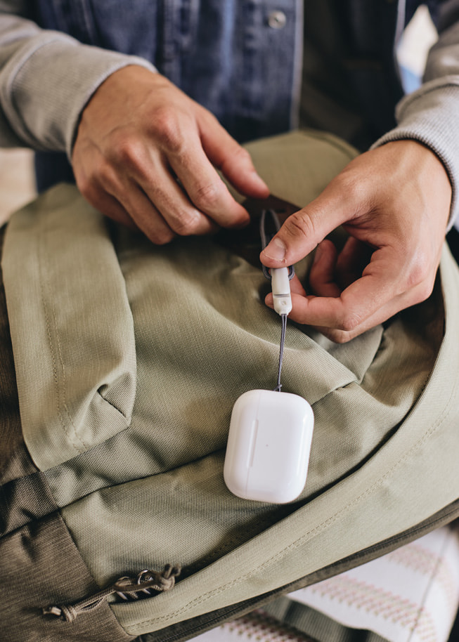 El enganche para correa del nuevo estuche de carga para los AirPods Pro de segunda generación colocado en una mochila.