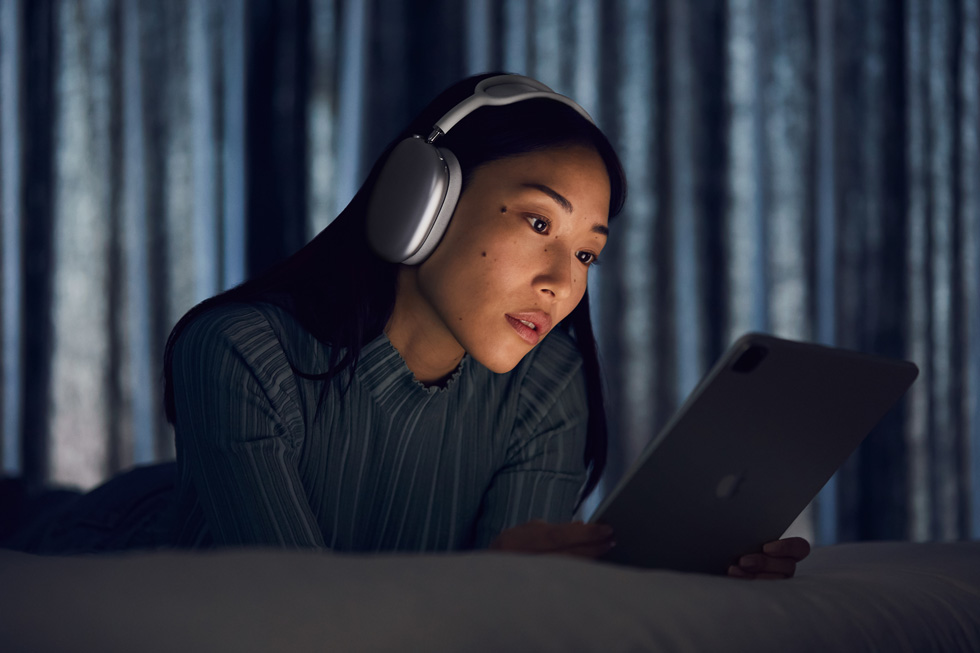 Une femme utilisant les AirPods Max avec l'iPad Pro.